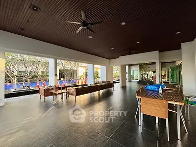 Spacious outdoor area with modern seating and ceiling fans, perfect for relaxation and gatherings.