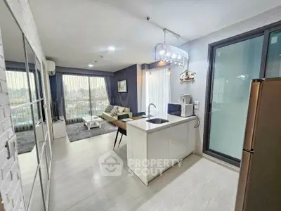 Modern open-layout living room and kitchen with large windows and stylish decor.