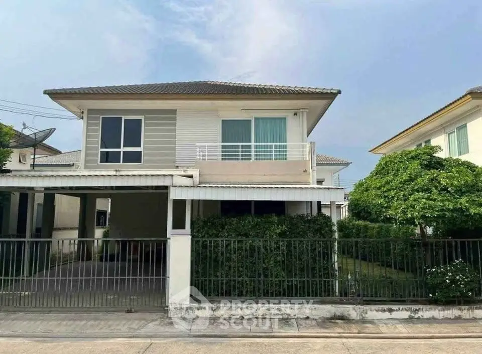 Charming two-story house with lush garden and spacious driveway in a serene neighborhood.