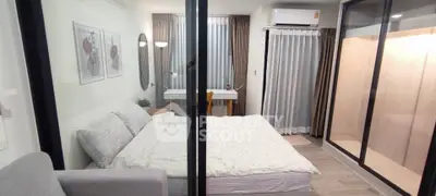 Modern bedroom with cozy decor and large windows in a stylish apartment.