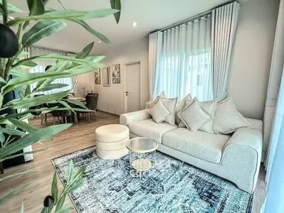 Elegant living room with plush sofa, stylish rug, and natural light, perfect for relaxation and entertaining.