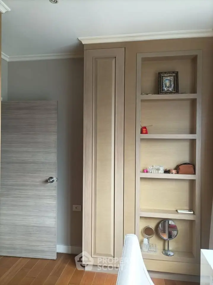 Modern interior with wooden shelves and door, showcasing elegant design and storage solutions.