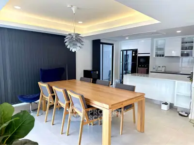Modern dining area with sleek kitchen and stylish lighting in open-concept home