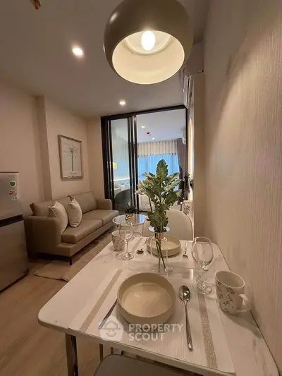 Cozy modern living room with dining area and stylish decor in a compact apartment.