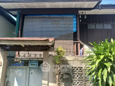 Charming rustic exterior with wooden accents and lush greenery, perfect for cozy living.