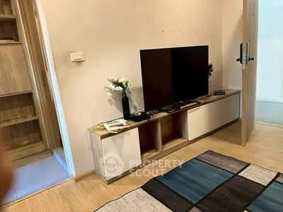 Modern living room with sleek TV stand and open door, showcasing contemporary design.