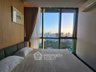 Luxurious bedroom with panoramic city view from large windows, featuring elegant decor and cozy ambiance.