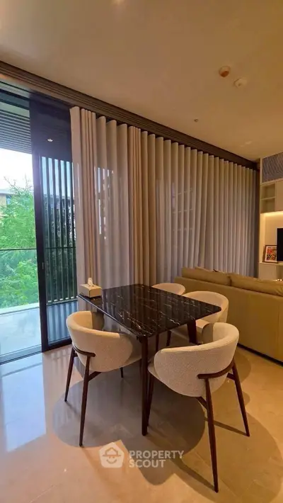 Modern dining area with elegant marble table and plush chairs, adjacent to a cozy living room and balcony view.