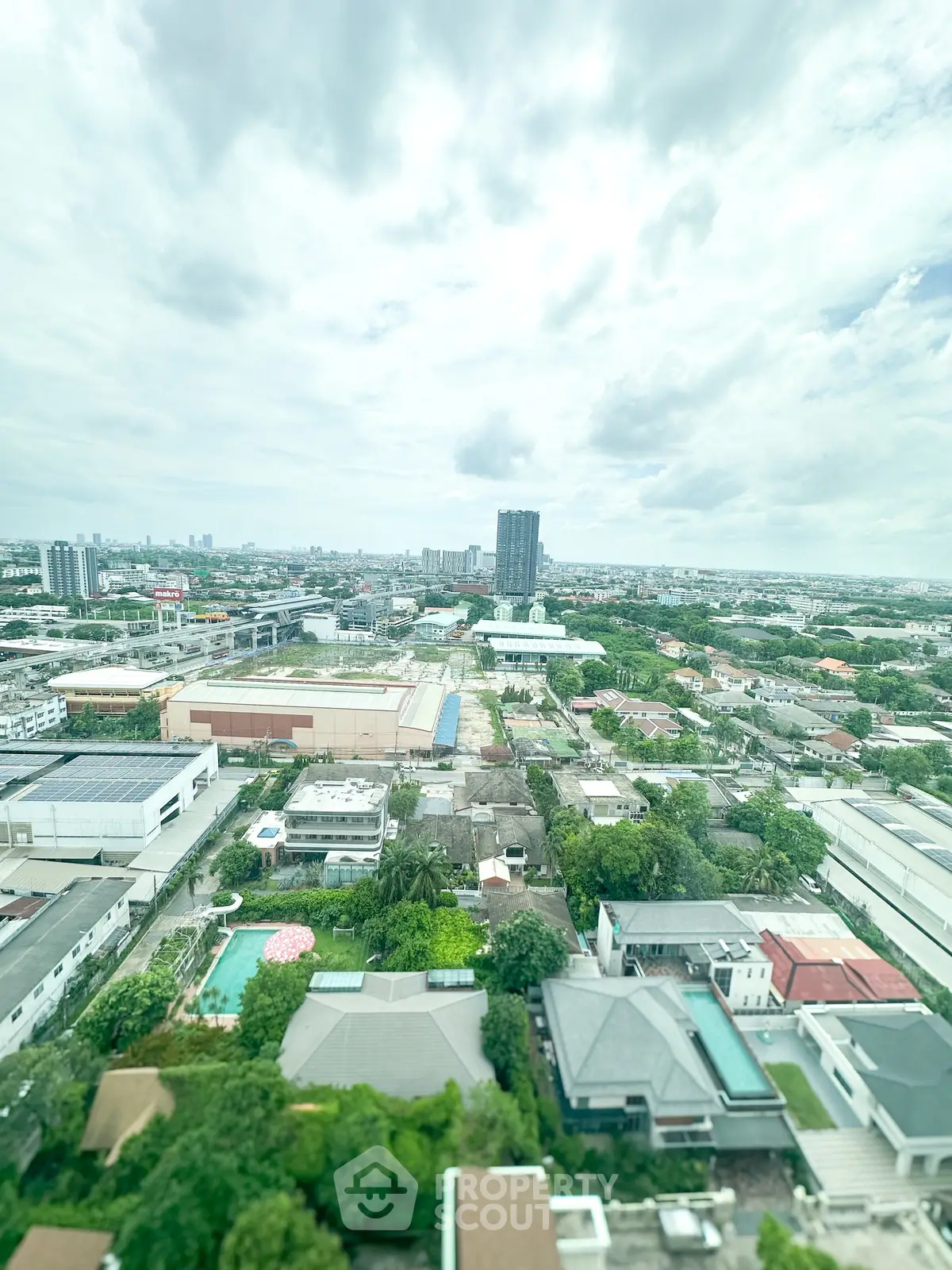 Stunning aerial cityscape view with lush greenery and urban skyline, perfect for real estate investment.