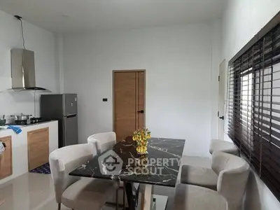 Modern kitchen with marble dining table and sleek appliances in a stylish open layout.