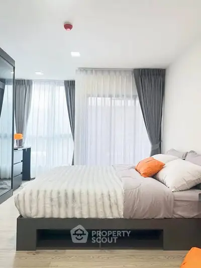 Modern bedroom with stylish decor and large windows in a contemporary apartment.