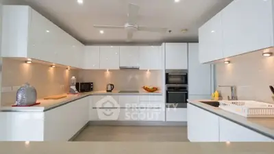 Modern kitchen with sleek white cabinets and built-in appliances