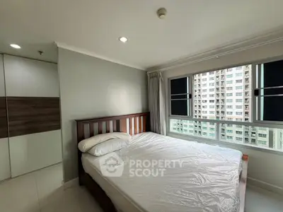 Spacious bedroom with large window offering city view in modern apartment