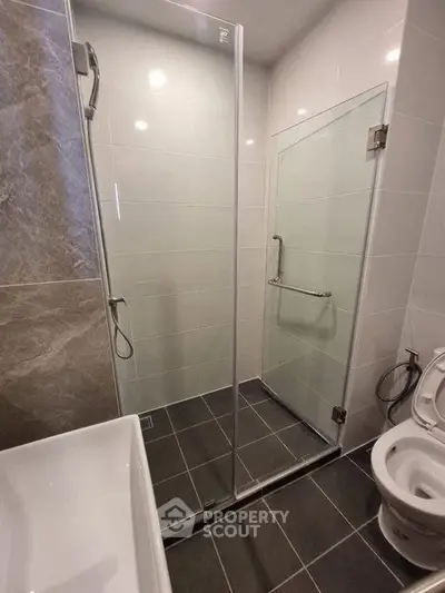 Modern bathroom with glass shower enclosure and sleek fixtures