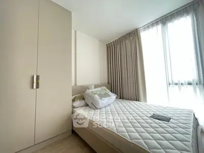 Bright and cozy bedroom with large window and modern furnishings