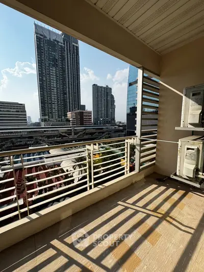 Spacious balcony with stunning cityscape view in modern high-rise building.