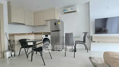 Modern kitchen with dining area featuring sleek appliances and stylish furniture.