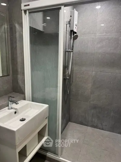 Modern bathroom with sleek shower and stylish sink in contemporary design.