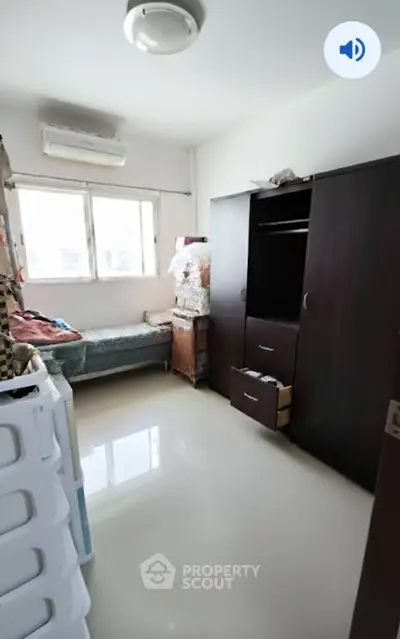 Cozy bedroom with ample natural light and modern storage solutions.