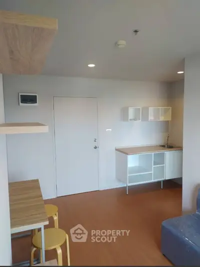 Modern minimalist studio apartment with open kitchen layout and wooden accents.