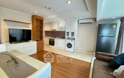 Modern open-plan living room with kitchen, featuring a washing machine and sleek appliances.