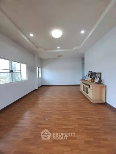 Spacious living room with wooden flooring and natural light