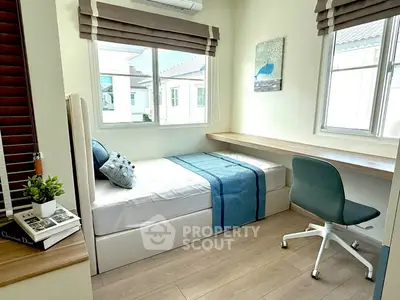 Cozy bedroom with modern decor, featuring a single bed, desk, and large windows for natural light.