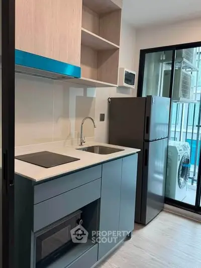 Modern kitchen with sleek appliances and balcony view in urban apartment