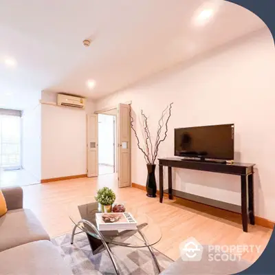 Spacious and well-lit living room with modern furnishings, sleek TV stand, cozy sofa set, and ambient lighting, perfect for relaxation and entertainment.