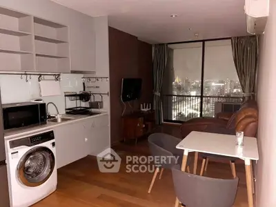 Modern living room with city view, featuring open kitchen, washing machine, and cozy seating area.
