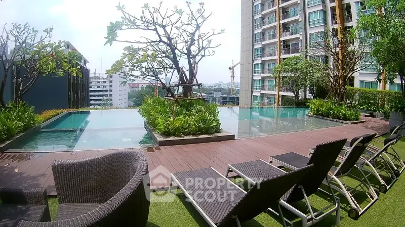 Luxurious rooftop pool area with modern lounge chairs and stunning city views in a high-rise building.