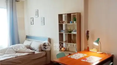 Cozy bedroom with study area, featuring a bed, desk, and bookshelf for a comfortable living space.