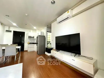 Modern living room with sleek furniture and open kitchen layout in a stylish apartment.