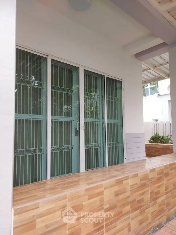 Charming exterior view of a modern home with stylish tiled porch and secure glass doors.