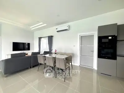 Modern living room with sleek furniture and integrated kitchen appliances