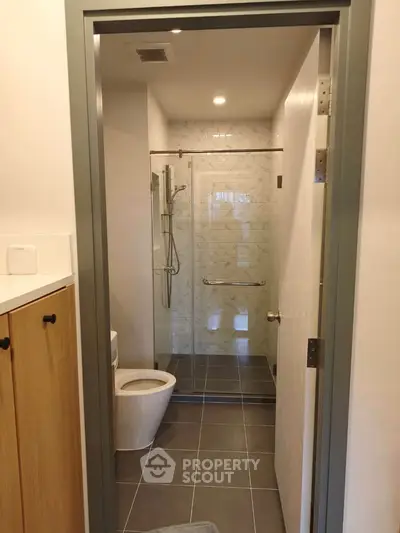 Modern bathroom with glass shower and sleek tile flooring