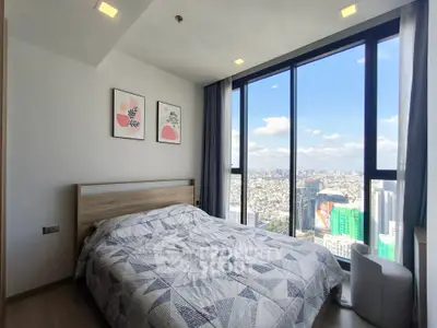 Spacious bedroom with stunning city view and modern decor in high-rise apartment.