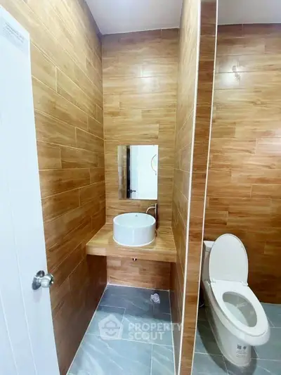 Modern bathroom with wood paneling and sleek fixtures