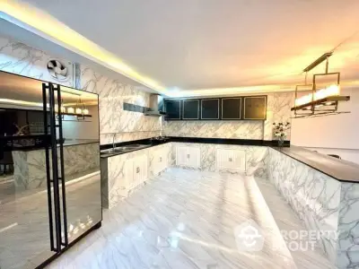 Luxurious modern kitchen with marble countertops, sleek black cabinets, and high-end appliances, perfect for culinary enthusiasts.