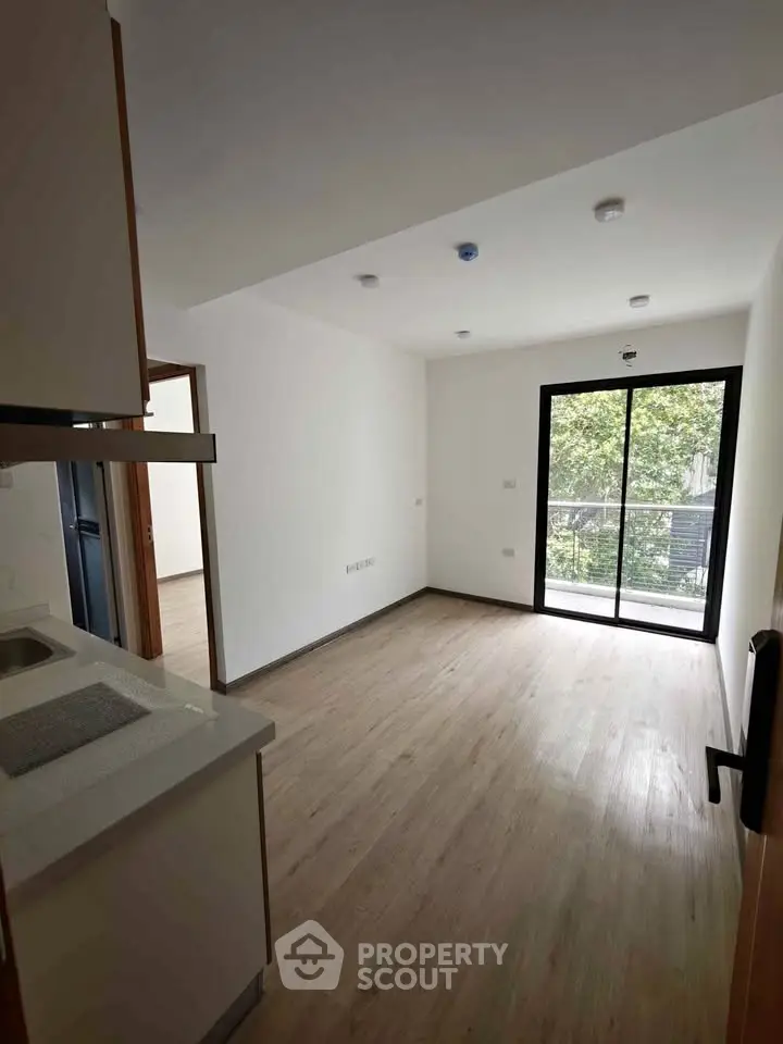 Modern apartment with open layout and large windows offering natural light and greenery views.