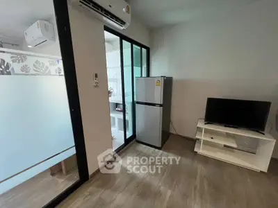 Modern apartment interior with sleek kitchen and living area featuring air conditioning and stylish decor.