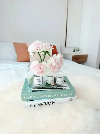 Elegant bedroom with stylish decor and cozy ambiance, featuring a plush bed and chic floral arrangement.