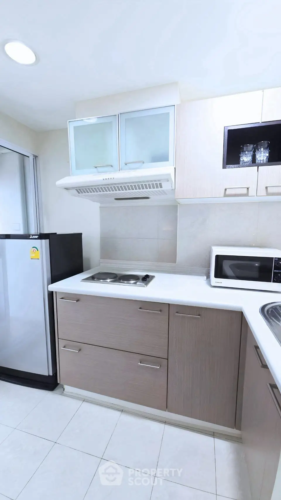 Modern kitchen with sleek cabinetry, built-in stove, and stainless steel appliances in a compact layout.