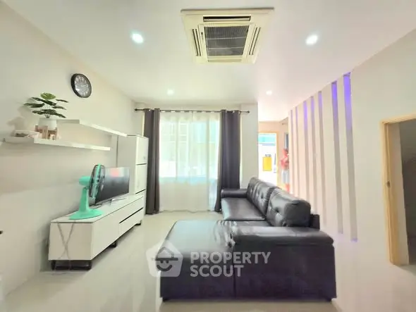 Modern living room with sleek leather sofa and wall-mounted TV unit