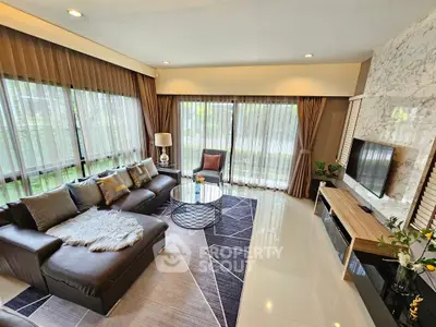 Luxurious living room with modern decor, large windows, and elegant furnishings in a spacious home.