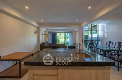 Spacious open-plan living and dining area with modern kitchen and garden view.