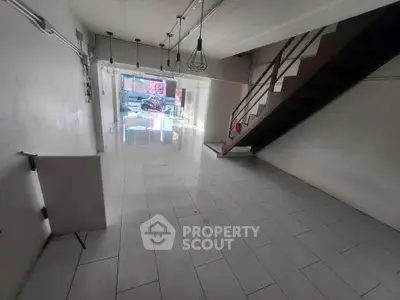 Spacious commercial space with modern lighting and staircase, ideal for retail or office use.