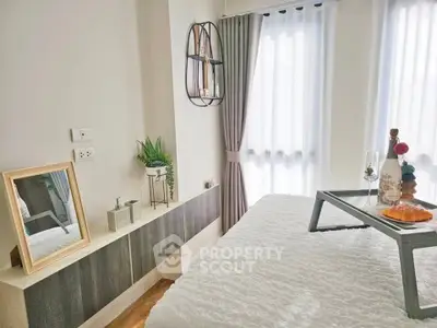 Cozy bedroom with modern decor and natural light, featuring a stylish bed and elegant furnishings.