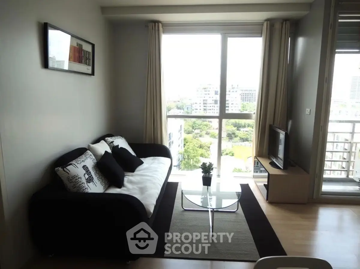 Modern living room with city view, stylish sofa, and sleek decor in a high-rise apartment.