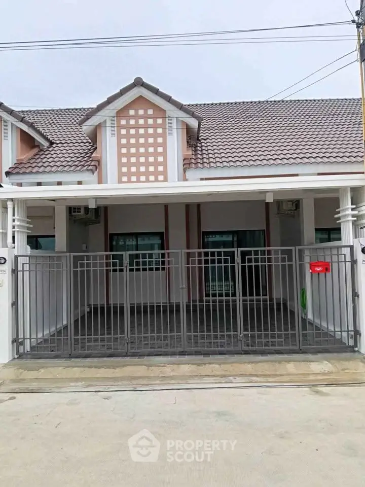 Charming single-story house with gated entrance and tiled roof, perfect for cozy living.